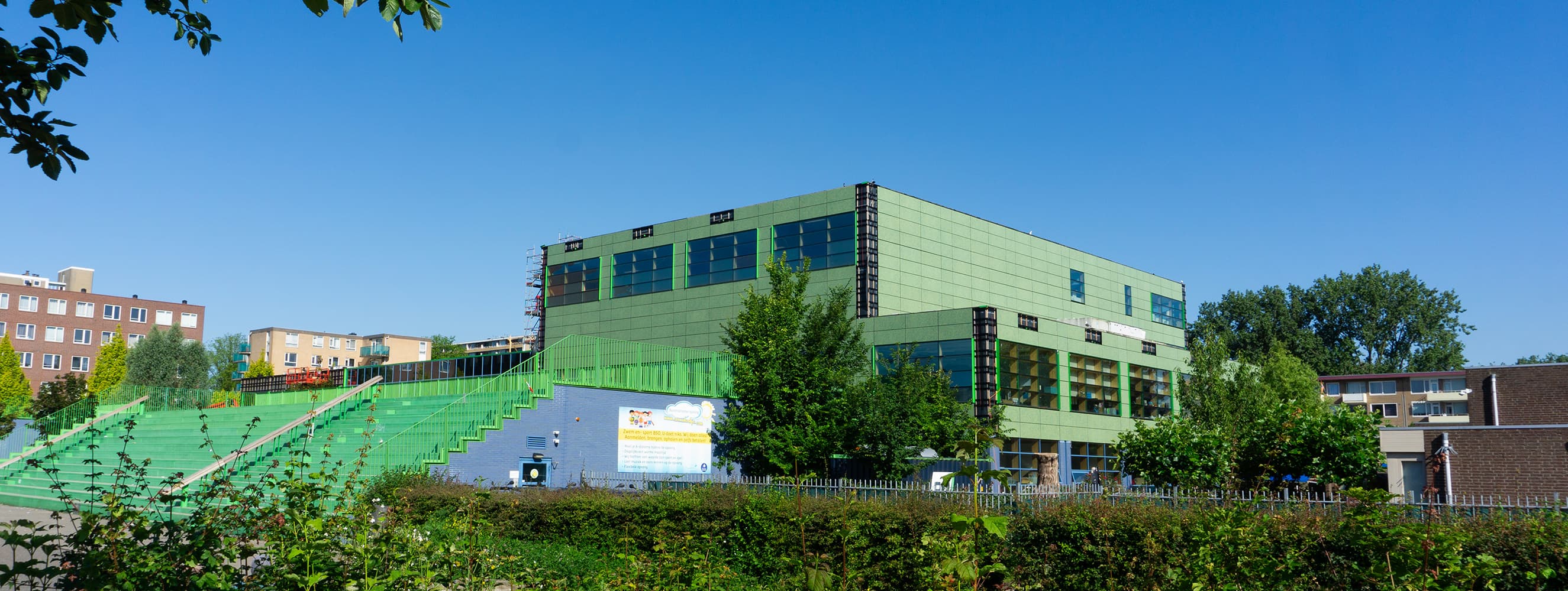 Groen gekleurde zonnepanelen op gevel O.B.S. De Kikker, Osdorp, Amsterdam | Solarix